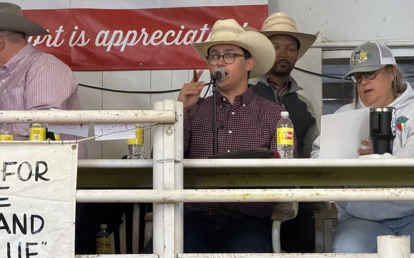 Tanner Beymer at the microphone alongside the livestock auction sale crew